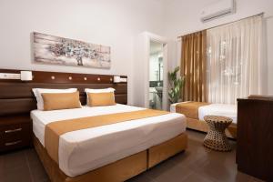 Habitación de hotel con 2 camas y TV en Semiramis Guesthouse en Adamas