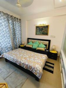 a bedroom with a bed with green pillows at Mansha niwas - kahana home in Vrindāvan