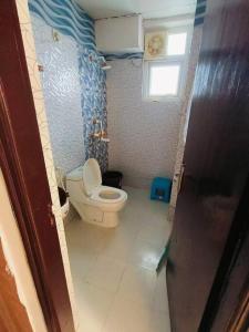 a small bathroom with a toilet and a window at Mansha niwas - kahana home in Vrindāvan