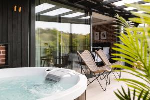 a hot tub in a room with chairs and a patio at The Cliffe at the Quay in Donegal