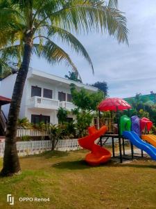 a playground in front of a house with a palm tree at Serene Resort Phú Quốc in Phu Quoc