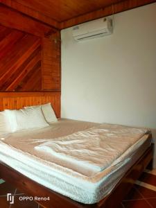 a large bed in a room with a wall at Serene Resort Phú Quốc in Phu Quoc
