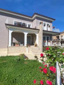 una grande casa con un balcone e rose rosse di Tavernetta La Lavanda annessa a Suite Apartment Assisi ad Assisi