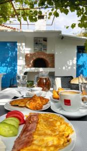 einen Tisch mit Tellern und einer Tasse Kaffee in der Unterkunft Ionian View B&B in Himarë