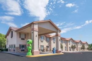 a building with a green statue in front of it at Super 8 by Wyndham Roswell in Roswell