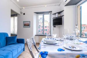 Casa Iole a Boccadasse - Genovainrelax في جينوا: غرفة معيشة مع طاولة وأريكة زرقاء