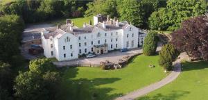 an aerial view of a large house on a green field at Court Colman Manor in Bridgend