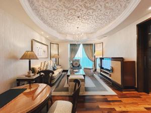 a living room with a couch and a tv at The Reverie Saigon in Ho Chi Minh City +37 photos