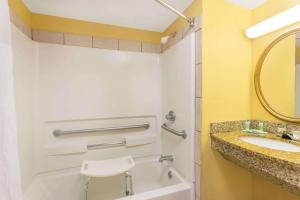 a bathroom with a sink and a toilet and a mirror at Howard Johnson by Wyndham Orlando-International Drive in Orlando