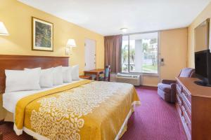 ein Hotelzimmer mit einem Bett und einem TV in der Unterkunft Howard Johnson by Wyndham Orlando-International Drive in Orlando