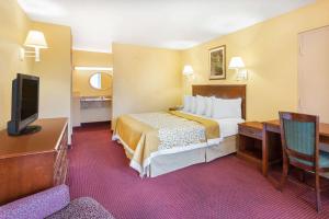 Habitación de hotel con cama y TV en Howard Johnson by Wyndham Orlando-International Drive, en Orlando
