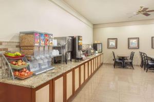a lobby with a counter with fruits and vegetables at Hawthorn Extended Stay by Wyndham Bloomington in Bloomington