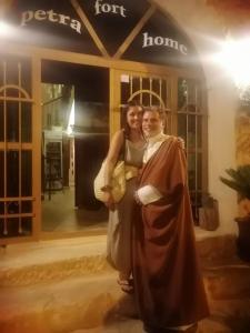 a man and a woman posing for a picture in front of a home at Petra fort hotel in Wadi Musa