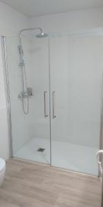 y baño con ducha y puerta de cristal. en Centre Esplai Albergue en El Prat de Llobregat
