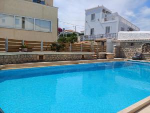 une grande piscine bleue en face d'un bâtiment dans l'établissement Villa Margarita, à Spetses