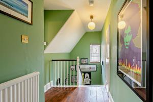 een hal met groene muren en een trap bij Old School Cottage in Sandgate