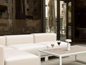 - deux verres de vin assis sur une table basse dans l'établissement Mercure Montpellier Centre Comédie, à Montpellier