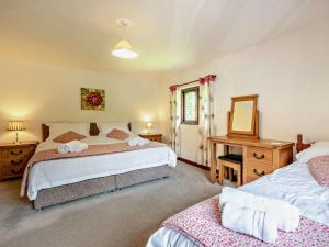 1 dormitorio con 2 camas, escritorio y espejo en 4 Bed in Bude LAMER, en Merryfield
