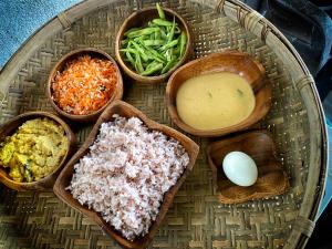 a plate of food with bowls of different types of food at Lapwing Lake Villa in Tissamaharama
