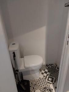 La salle de bains est pourvue de toilettes blanches et de carrelage noir et blanc. dans l'établissement Home St. Germain, à Trouville-sur-Mer