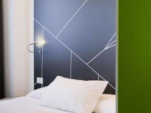 a bed with a headboard with a chart on it at Mercure Milano Agrate Brianza in Agrate Brianza