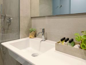 a white sink in a bathroom with a mirror at Mercure Milano Agrate Brianza in Agrate Brianza