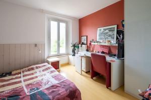 Schlafzimmer mit roten Wänden, einem Bett und einem Schreibtisch in der Unterkunft Villa Provence au calme avec piscine in Toulon