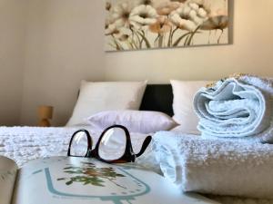 a pair of glasses sitting on a bed with towels at Apartment Adri in Rovinj