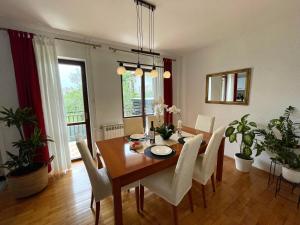 een eetkamer met een houten tafel en witte stoelen bij Apartment Adri in Rovinj