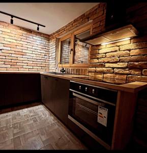 a kitchen with a stove and a brick wall at Vila Zapis in Pirot