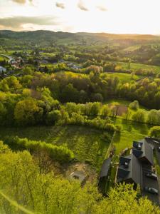 an aerial view of a green field with a house at Bieszczadzka Hawira - Domki w Centrum przy Jeziorze z Widokiem dla Rodzin in Polańczyk