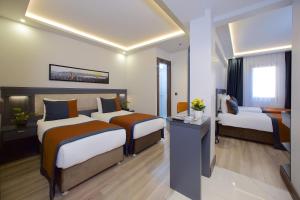 Cette chambre comprend deux lits et une télévision. dans l'établissement Hotel Eyfel, à Istanbul
