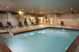 een groot zwembad in een hotel met stoelen en tafels bij Hyatt Place Oklahoma City Bricktown in Oklahoma City