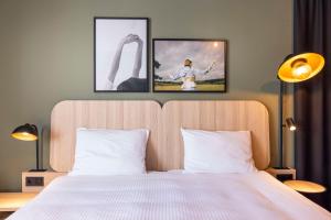 um quarto com uma cama com duas fotografias na parede em Scandic Wrocław em Breslávia