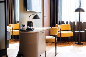 una habitación de hotel con sillas, escritorio y una habitación en Scandic Wrocław en Breslavia