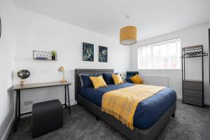 Schlafzimmer mit einem Bett und einem Schreibtisch in der Unterkunft Spacious & Modern 4-Bedroom Townhouse in Manchester