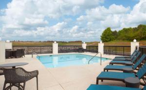 a swimming pool with chairs and a table at Hampton Inn Athens in Athens