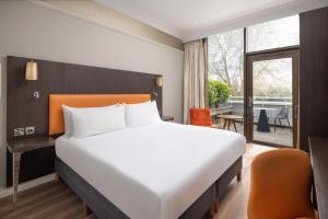 una camera con letto e balcone di DoubleTree by Hilton London - Hyde Park a Londra