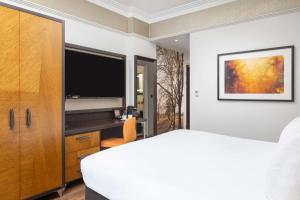 una camera con letto e TV a schermo piatto di DoubleTree by Hilton London - Hyde Park a Londra