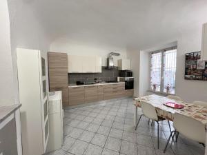 a kitchen with a table and a white refrigerator at La Casa di Ania in Savona