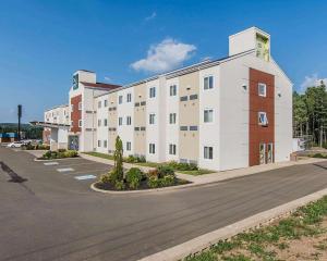 um grande edifício branco com estacionamento em Quality Inn Moncton em Moncton