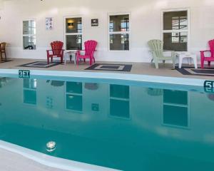 a group of chairs sitting around a swimming pool at Quality Inn in Moncton