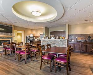 a restaurant with tables and chairs and a kitchen at Quality Inn Moncton in Moncton