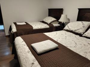 卡爾德拉的住宿－HOTEL QUINTA ESTACIÓN，配有衬衫的酒店客房内的两张床