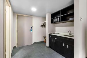 eine Küche mit schwarzen Schränken, einem Waschbecken und einer Tür in der Unterkunft Quality Inn & Suites Altoona Pennsylvania in Altoona
