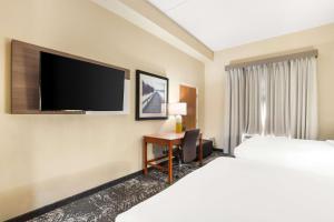 Habitación de hotel con cama y escritorio con TV. en Comfort Suites Columbia at Harbison en Columbia