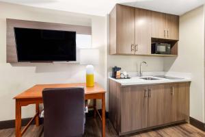 una pequeña cocina con mesa y fregadero en Comfort Suites Columbia at Harbison en Columbia