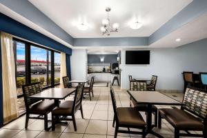 a dining room with tables and chairs and a kitchen at Quality Inn I-81 Exit 23 in Bulls Gap