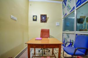 una stanza con tavolo, due sedie e un orologio di SPOT ON Shashi Prabha Palace a Deoghar