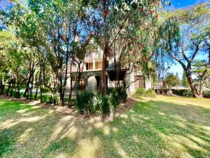 una casa en un patio con árboles y césped en Wenzi Luxury Home en Arusha
